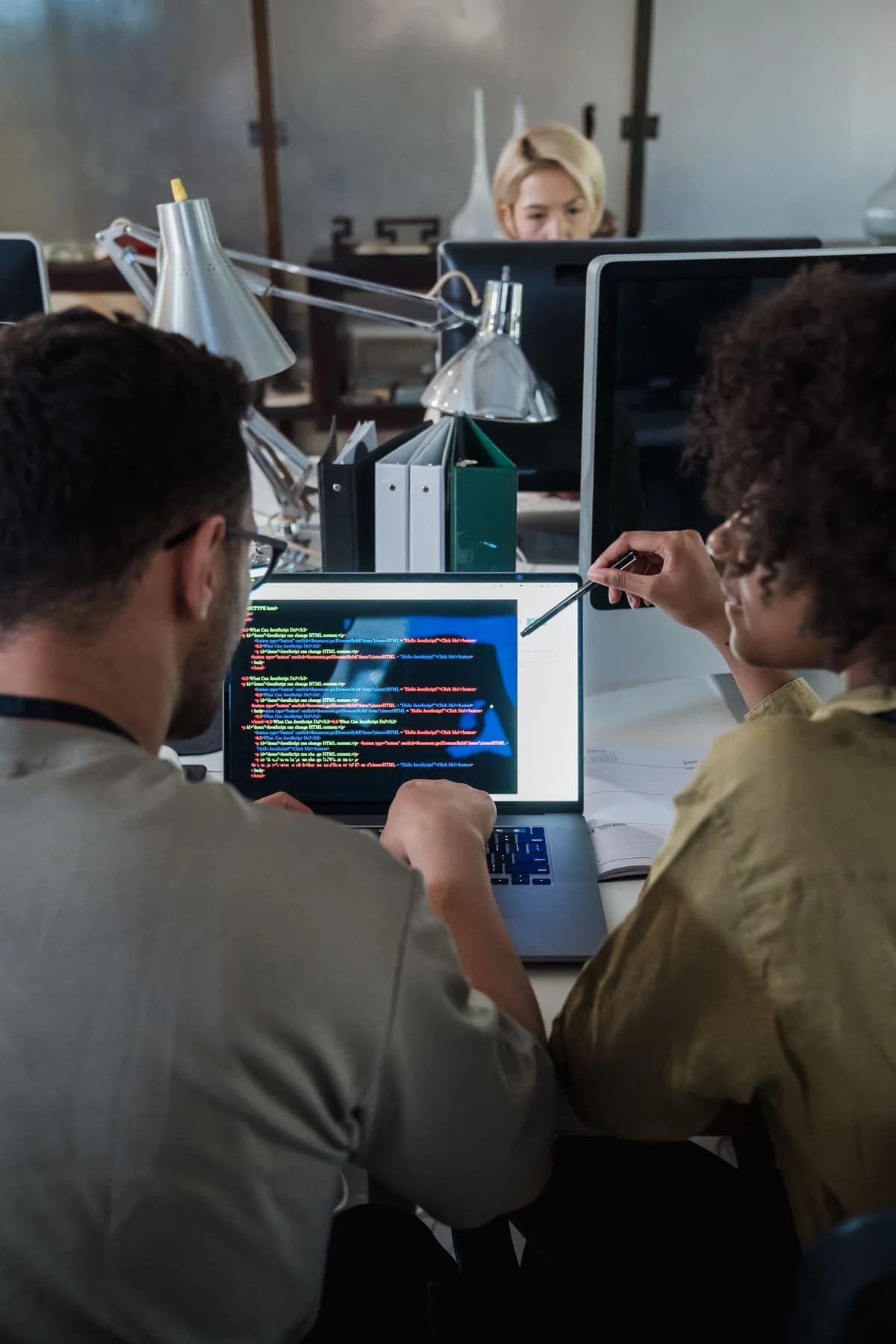 Colleagues discussing software implementation (contextual stock photograph)